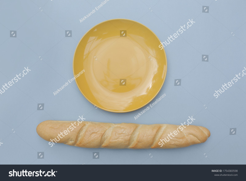stock-photo--baguette-of-white-bread-and-a-yellow-glossy-plate-on-a-blue-background-1754383598